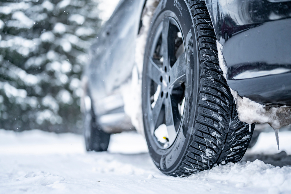 Auto se zimními pneumatikami na zasněžené silnici